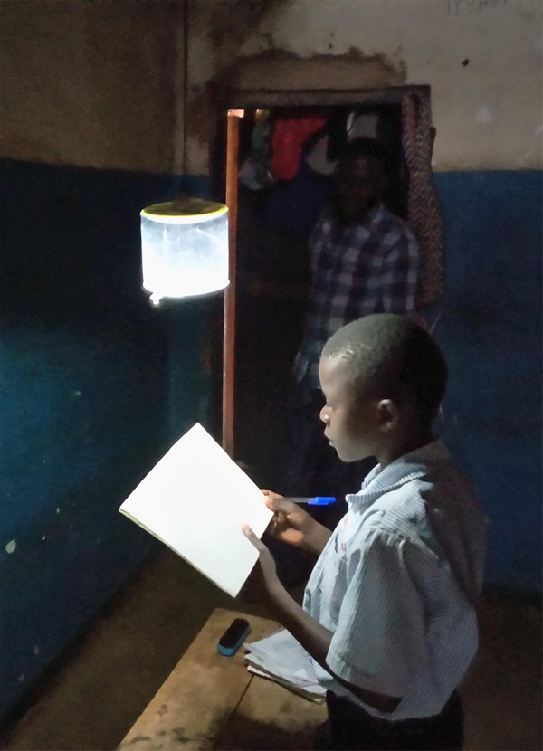 우간다 카물리주 학생이 태양광 랜턴을 켜고 공부하는 모습.