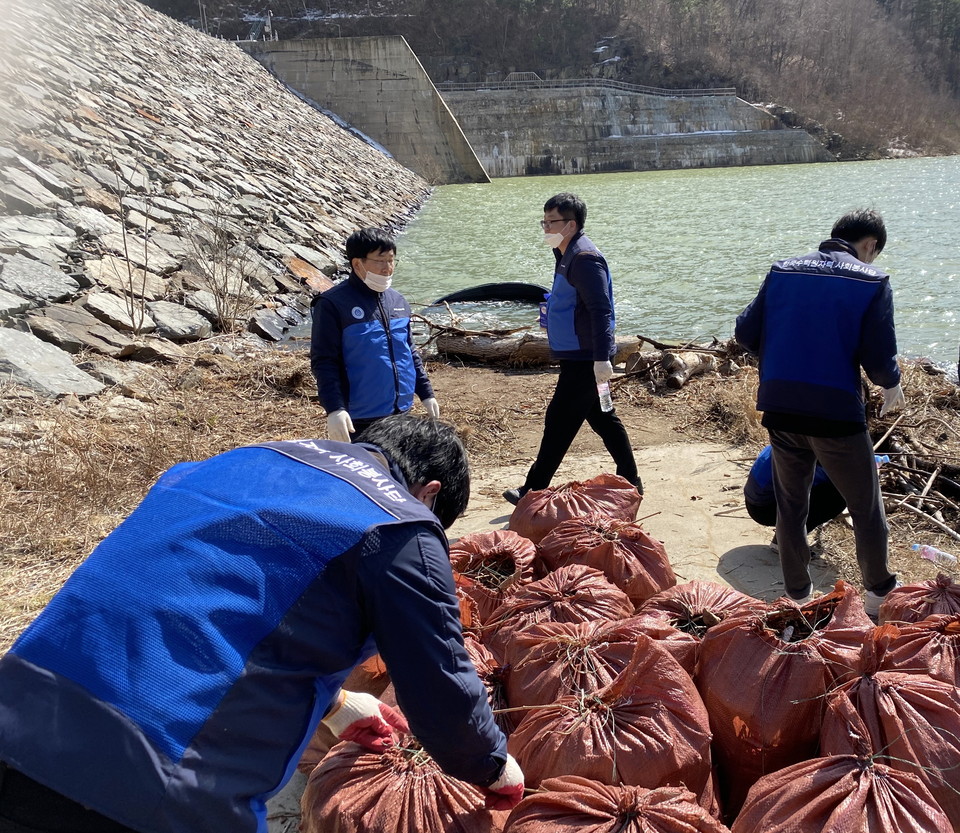 한수원 한강수력본부 임직원들이 도암댐에서 쓰레기를 수거하고 있다.