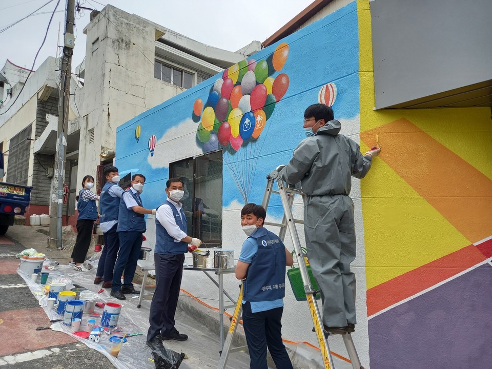 지난 6일 울산 태화종합시장에서 임상경 에너지공단 상임감사(오른쪽에서 세 번째)와 직원들이 벽화 그리기 사회공헌활동을 하고 있다.