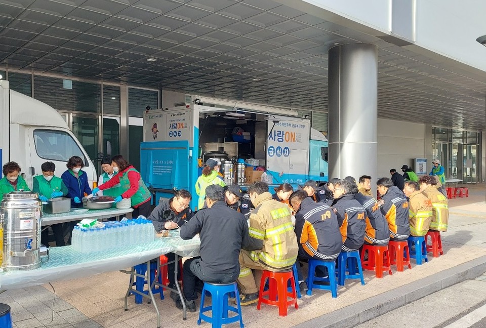 강릉 산불 진압 소방관들이 한수원 사랑 온(ON) 급식차에서 식사를 하고 있다.