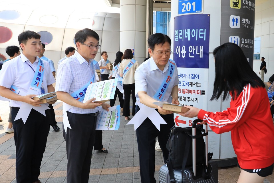 14일 광주송정역에서 진행된 ‘하루 1kWh 줄이기’ 캠페인에 참여한 김홍연 한전KPS 사장(오른쪽 두 번째)이 직원들과 함께 시민에게 에너지절약 안내문과 홍보 물품을 전달하고 있다.