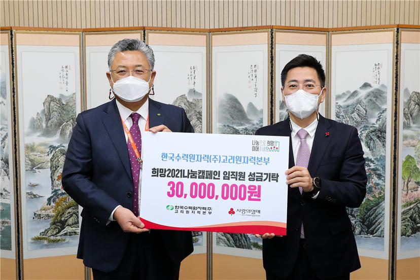박인식 고리본부장(왼쪽)이 박은덕 부산사회복지공동모금회 사무처장에게 성금 3000만원을 전달한 뒤 함께 기념촬영을 하고 있다.
