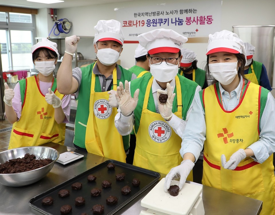 황창화 한난 사장(왼쪽 세 번째)과 이홍성 노조위원장(왼쪽 두 번째)이 직원들과 함께 성남시 예방접종센터 종사자를 응원하기 위한 쿠키를 만들고 있다.