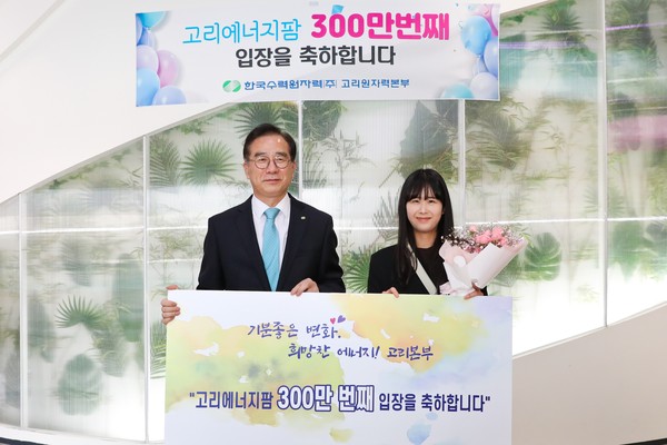 이광훈 고리본부장(왼쪽)이 고리에너지팜 300만번째 관람객인 홍종혜씨에게 꽃다발을 전달한 뒤 함께 기념촬영을 하고 있다.